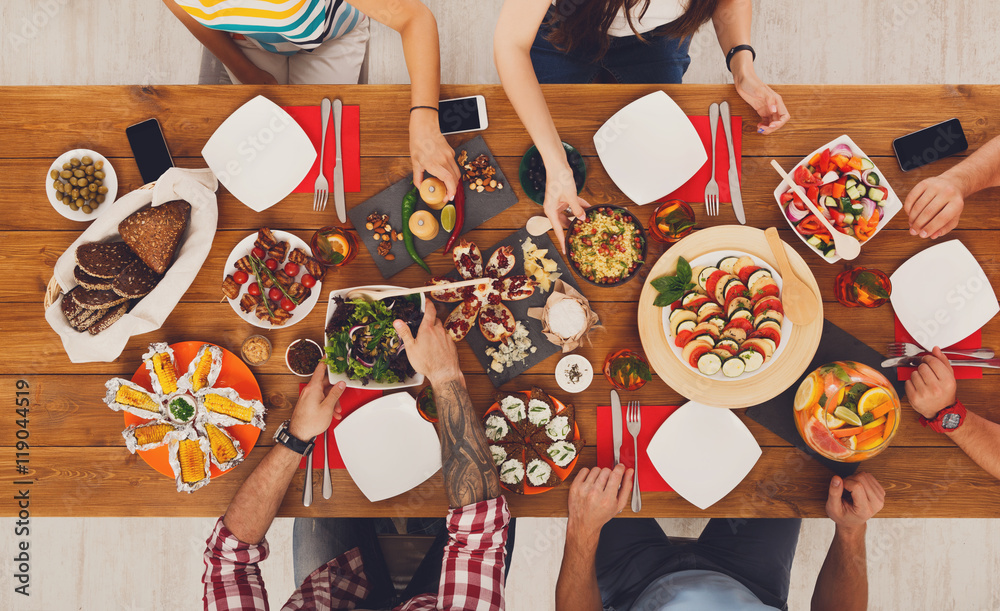 Wall mural people eat healthy meals at festive table dinner party