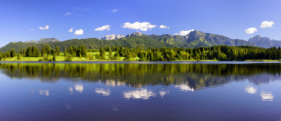 Fototapeta premium Panorama Landschaft in Bayern im Allgäu mit Forggensee und Berge