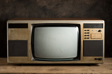 old television on old wood table with grunge background