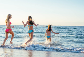 three girls having fun on beach, friends on beach in sunset light