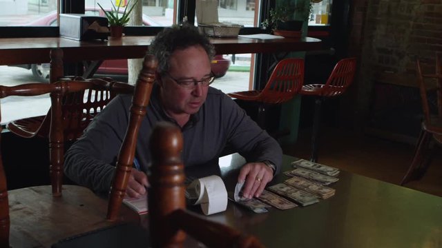 Small business owner counting cash at restaurant - 4K