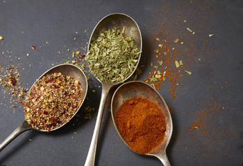Assorted herbs and spices on a rustic slate background