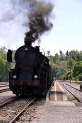 Steam locomotive on station with black smoke
