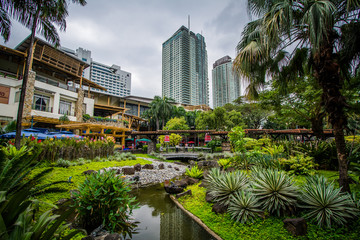 Gardens and skyscrapers at Greenbelt Park, in Ayala, Makati, Met - obrazy, fototapety, plakaty