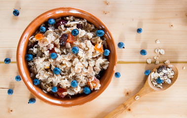 Serving muesli scattering of wild berries on wooden table