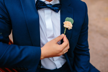 The groom holds elegant boutonniere