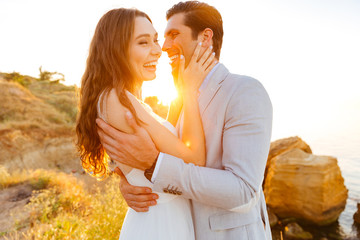 Just-married couple standing at the beach