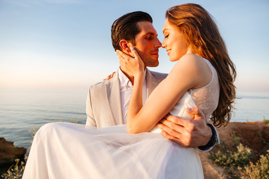 Attractive bride and groom getting married by the beach
