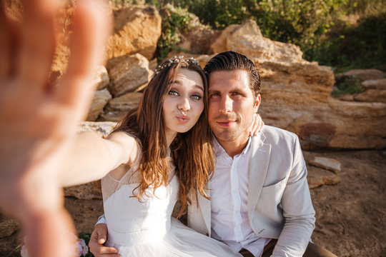Happy young married couple making selfie at the beach