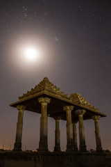 The royal cenotaphs of historic rulers, also known as Jaisalmer Chhatris, at Bada Bagh in Jaisalmer, Rajasthan, India. Night shot of ruins with a moon