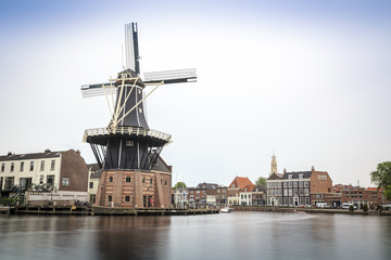 Fototapeta na wymiar Haarlem by the canal with windmill, The Netherlands