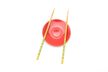 Plate with chopsticks on white background