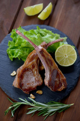 Barbecued lamb steaks served with salad on a stone slate tray