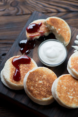 Close-up of cheese pancakes served with jam and sour cream
