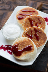 Curd fritters with sour cream and jam, close-up, selective focus