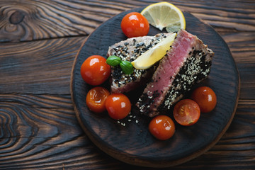 Rustic wooden serving board with sliced roasted tuna steak