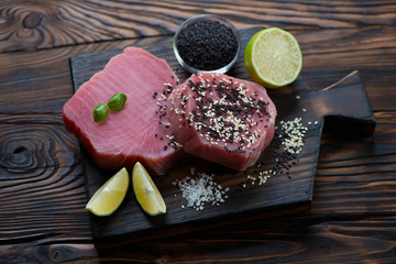 Raw fresh tuna steaks on a rustic wooden chopping board