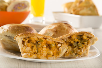 Empada Brazilian snack. pie with palm on white plate on wooden b