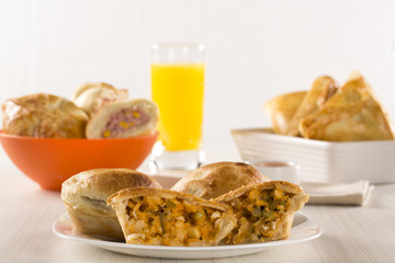Empada Brazilian snack. pie with palm on white plate on wooden b