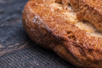 Rustic bread on wood table. Dark moody background with free text space.