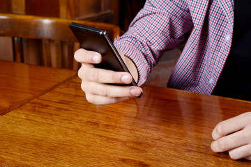 Latin man using his smartphone at a cafe.