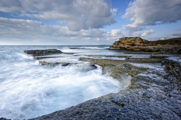 Fototapeta na wymiar there are pink rocks near to sea with long exposure shot