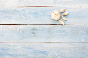 Garlic on blue wooden board, top view