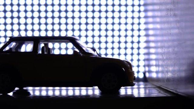 Empty car crashing into wall. Crash test laboratory concept. Magenta lights background, super slow motion video