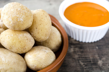 Canarian potatoes (papas arrugadas) with mojo sauce on wooden table

