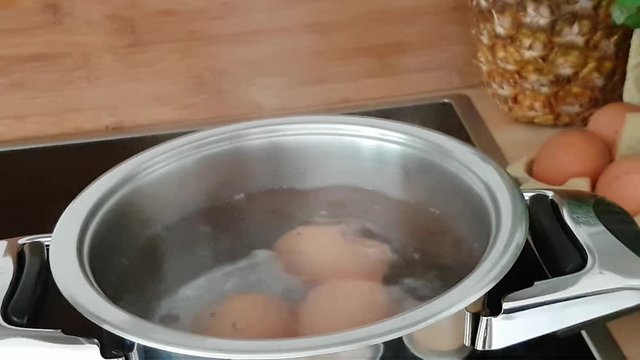 Eier kochen - Eier in einen Topf mit kochendem Wasser
