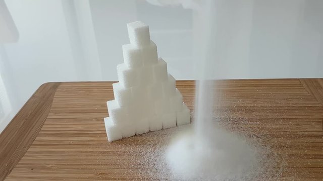 Zuckerw&uuml;rfel und Zucker der aufgesch&uuml;ttet wird