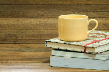 Coffee mug and books on wooden.