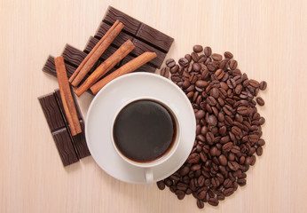 Coffee cup and chocolate on a wood background