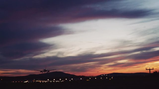 Big airplane landing in airport at sunset, sunset, evening, no people around. Outside shooting. Airport lights on the background.
