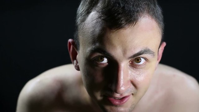 Portrait of undressed guy, black background