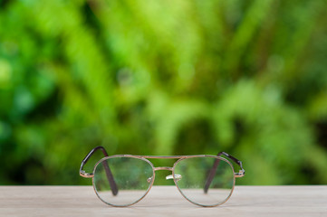 Fototapeta na wymiar Old eyeglasses on wooden table.