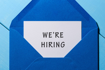 We are hiring phrase written in the paper at blue envelope. human resources concept