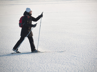 Toned image of an adult woman going skiing on snow crust 