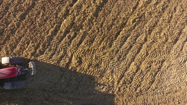 Roter Traktor in der Landwirtschaft pfl&uuml;gt den Acker