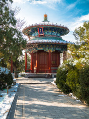Toned image of traditional Chinese pavilion standing in Beijing near the Forbidden City in the winter against the blue sky with clouds. Written here - All Round View Pavilion