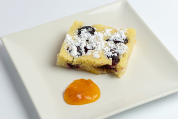 Homemade plum cake on white plate.