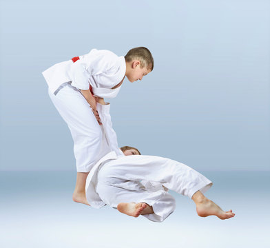 On a light background athletes train judo throws