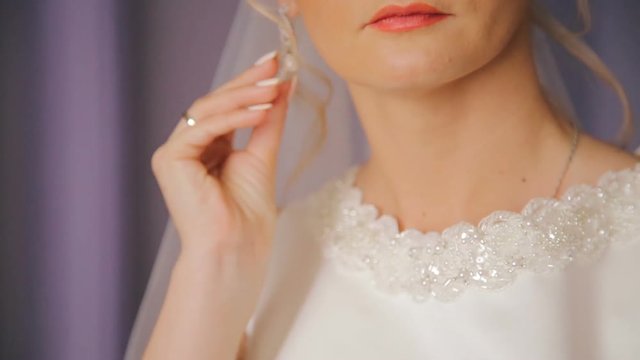 Close up of elegant bride wears beautiful earrings