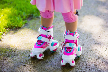 Little girl with roller skate shoes in a park