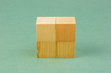 wooden geometric cube on a green background