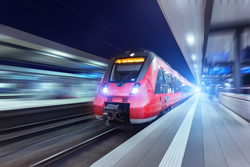 Fototapeta premium Nowoczesny wysokiej prędkości czerwony pociąg pasażerski w nocy
