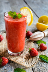 Refreshing strawberry smoothie with lemon juice in a glass jar