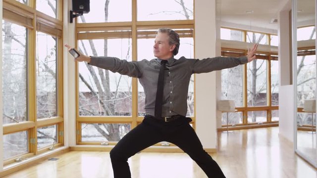 Businessman juggles yoga and work - 4K