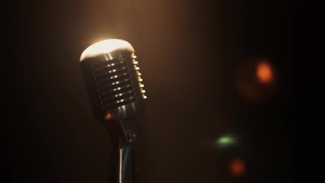 View of concert vintage glow microphone stay on stage under spotlight. Smoke. Zoom out