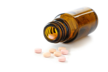 pill bottle spilling small pink pills on a white background, isolated with schadows